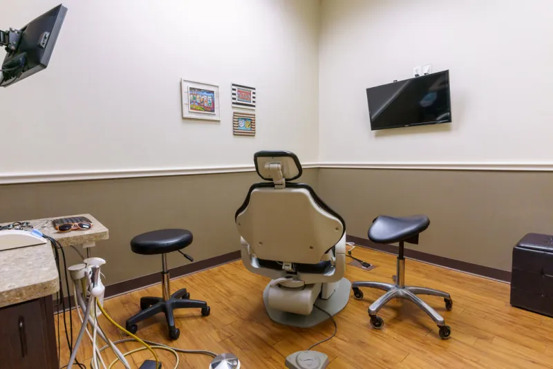 Treatment room with ceiling-mounted TV and kid-friendly artwork at Tech Ridge Dental